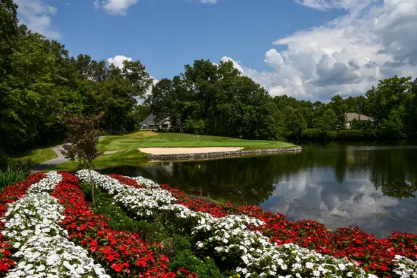 Dorchester Golf Club green beside a pond and flower beds