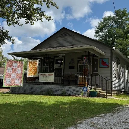 Grandma’s House Quilt Shop with quilts hanging outside the porch