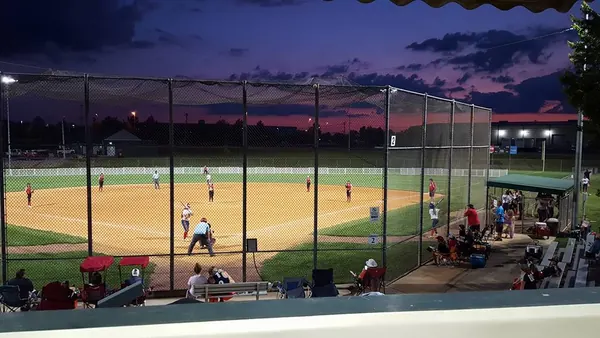 A softball game at Crossville Centennial Park under the lights at dusk